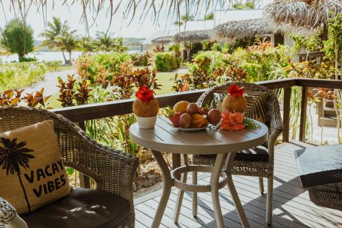 a table with a bowl of fruit on a balcony at Tai Roto Bay in Arutanga