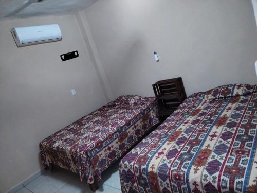 two beds in a hotel room with at Casa Jeymar in Coyuca