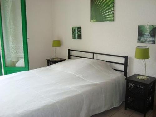 1 dormitorio con 1 cama blanca y 2 mesitas de noche en Appartement Amélie-les-Bains-Palalda, 2 pièces, 2 personnes - FR-1-703-1, en Amélie-les-Bains-Palalda