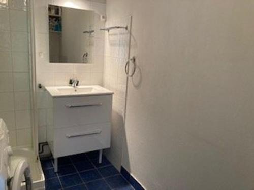 une salle de bain blanche avec un lavabo et un miroir dans l'établissement Appartement F2 Confortable à Amélie-les-Bains – Balcon, Parking, Proche Thermes, Animaux Bienvenus - FR-1-703-15, à Amélie-les-Bains-Palalda