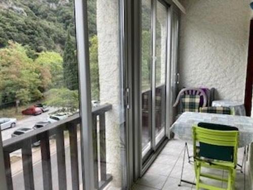 un balcon avec une table, des chaises et une fenêtre dans l'établissement Appartement F2 Confortable à Amélie-les-Bains – Balcon, Parking, Proche Thermes, Animaux Bienvenus - FR-1-703-15, à Amélie-les-Bains-Palalda
