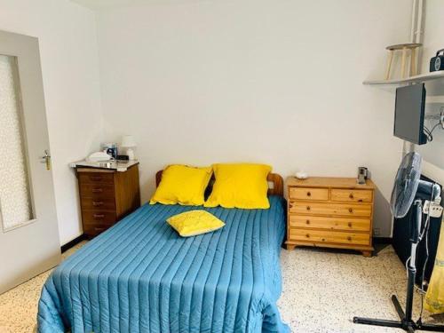 - une chambre avec un lit doté de draps bleus et d'oreillers jaunes dans l'établissement Studio pour cure avec balcon, parking et WiFi à 2 pas des thermes d'Amélie-les-Bains. - FR-1-703-19, à Amélie-les-Bains-Palalda