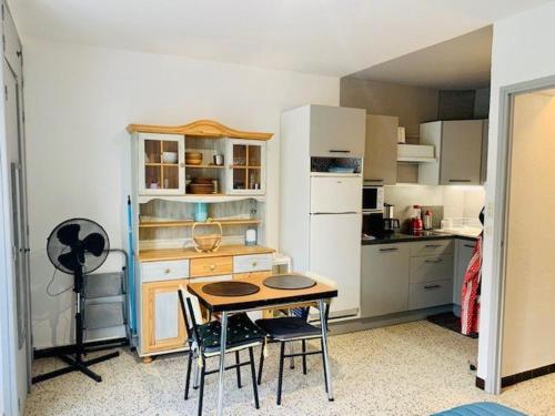 une petite cuisine avec une table et des chaises. dans l'établissement Studio pour cure avec balcon, parking et WiFi à 2 pas des thermes d'Amélie-les-Bains. - FR-1-703-19, à Amélie-les-Bains-Palalda