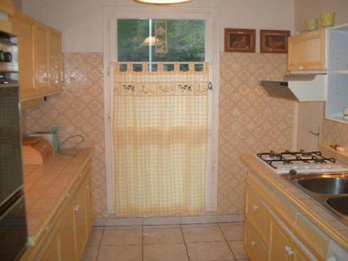 une petite cuisine avec un évier et une fenêtre dans l'établissement Charmant F2 avec Garage et Terrasse, 3 couchages, proche cures et centre-ville, Amélie-les-Bains - FR-1-703-12, à Amélie-les-Bains-Palalda