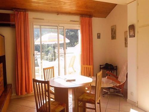 - une salle à manger avec une table et un parasol dans l'établissement Appartement F2 climatisé avec terrasse, parking, à 600m des thermes - Amélie-les-Bains - FR-1-703-27, à Amélie-les-Bains-Palalda