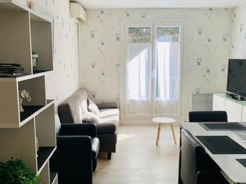 - un petit salon avec un canapé et une fenêtre dans l'établissement Appartement F3 rénové, 2 à 6 pers, clim, wifi, garage fermé, animaux OK, Amélie-les-Bains - FR-1-703-31, à Amélie-les-Bains-Palalda