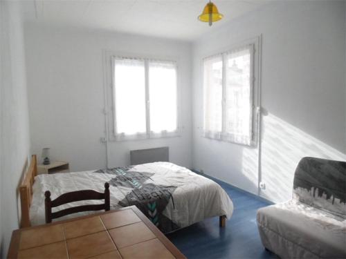 - une chambre avec un lit, un canapé et deux fenêtres dans l'établissement Appartement F3 avec balcon exposé sud, 2 chambres, proche commodités à Amélie-les-Bains - FR-1-703-42, à Amélie-les-Bains-Palalda