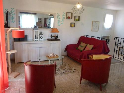 un salon avec un canapé rouge et une table dans l'établissement Maison F3 avec jardin, terrasse, parking, WIFI, animaux admis - Céret - FR-1-703-43, à Céret