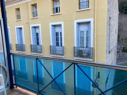 - un balcon avec une piscine en face d'un bâtiment dans l'établissement Studio cosy avec parking à 50m des Thermes, 2 couchages - Amélie-les-Bains - FR-1-703-55, à Amélie-les-Bains-Palalda