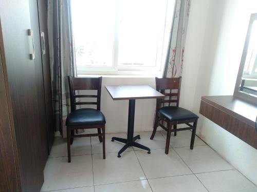 1 mesa y 2 sillas en una habitación con ventana en Khách sạn Crown - Gần đại học Nông Lâm TN, en Thái Nguyên