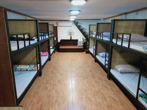 Pakse Backpacker Hostel2023 في باكسي: مجموعة من الأسرّة ذات الطابقين في الغرفة