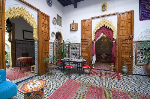 a room with a large doorway with a table and chairs at Riad Dar Jabador in Sale