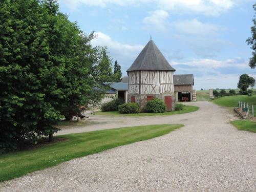 an old barn with a tower on a gravel road at Chambres d'Hôtes de la Bucaille in La Bucaille