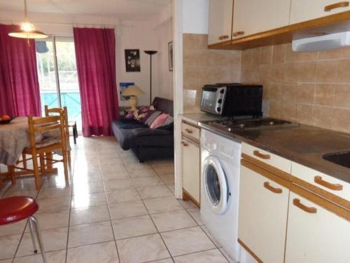 une cuisine avec lave-linge et un salon dans l'établissement Appartement F2 confortable avec balcon près des Thermes d'Amélie-les-Bains - FR-1-703-61, à Amélie-les-Bains-Palalda