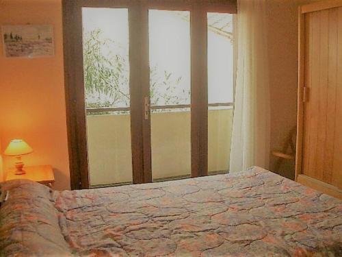 une chambre avec un lit et une grande fenêtre dans l'établissement Appartement F2 avec balcon, 200m des cures, proche commerces, tout équipé, charges en sus - FR-1-703-76, à Amélie-les-Bains-Palalda