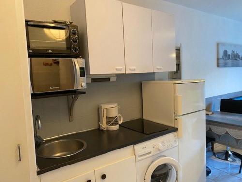 une petite cuisine avec un évier et un micro-ondes dans l'établissement Studio rénové avec balcon, ascenseur, 2 couchages à Amélie-les-Bains, animaux acceptés - FR-1-703-70, à Amélie-les-Bains-Palalda