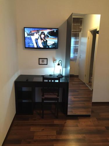 a room with a desk and a television on the wall at Hotel Engel in Waldbronn
