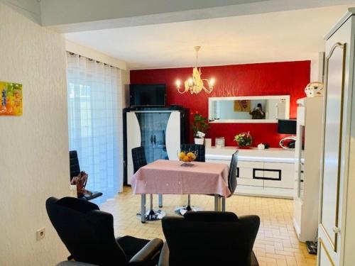 une cuisine avec une table et un mur rouge dans l'établissement Studio cosy avec terrasse - 2 pers - Amélie-les-Bains - FR-1-703-58, à Amélie-les-Bains-Palalda