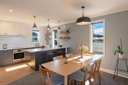 a kitchen and dining room with a table and chairs at Trendy Townhouse in Nelson