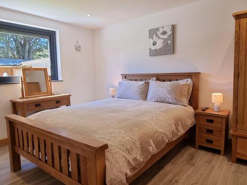 sypialnia z łóżkiem, lustrem i oknem w obiekcie Dronefield Lodge w mieście Pitney