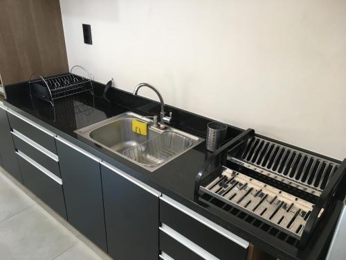 a kitchen counter with a sink and drying racks at Cantinho Estrelado - Casa automatizada com ALEXA in Brotas