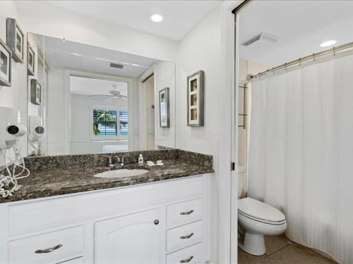uma casa de banho com um lavatório, um WC e um espelho. em Estero Island Beach Villas 204, Sleeps 8, 2 Bedrooms, Gulf Front, Heated Pool em Fort Myers Beach