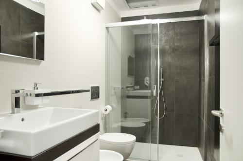 ein Bad mit einer Dusche, einem Waschbecken und einem WC in der Unterkunft Green Apartment in Bozen