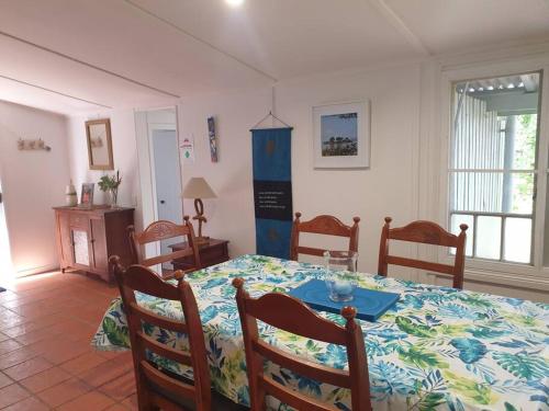 uma sala de jantar com uma mesa e quatro cadeiras em Turtle Cottage Magnetic Island em Picnic Bay