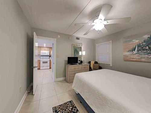 a bedroom with a bed and a ceiling fan at Ocean Breeze West #204 in Perdido Key