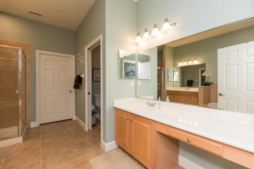 a bathroom with a sink and a large mirror at SouthernVilla Ticket to Paradise in Palm Coast