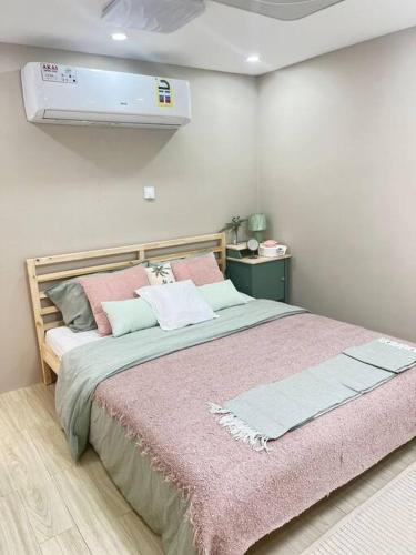 una camera da letto con un grande letto con una coperta rosa di افتار شالية avatar chalet a Al Raka