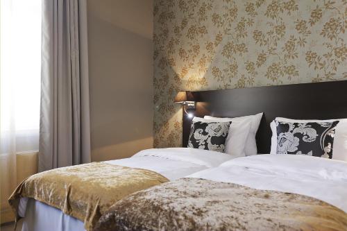 a bedroom with a bed with white sheets and pillows at Saga Hotel Oslo, WorldHotels Crafted in Oslo