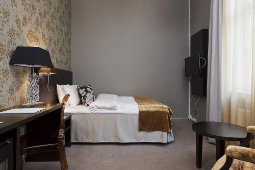 a hotel room with a bed and a desk and a chair at Saga Hotel Oslo, WorldHotels Crafted in Oslo
