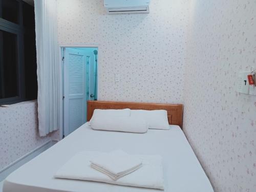 a bedroom with a white bed with a blue door at MOTEL MINH ANH in Ấp Rạch Mẹo