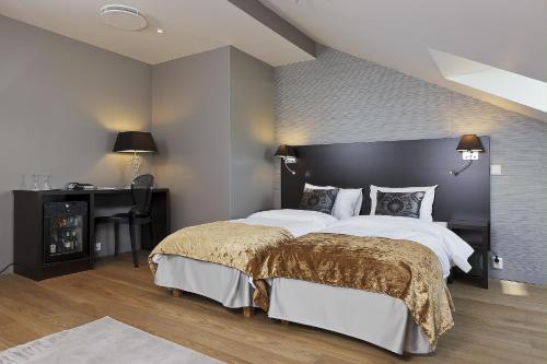 a bedroom with a large bed and a desk at Saga Hotel Oslo, WorldHotels Crafted in Oslo