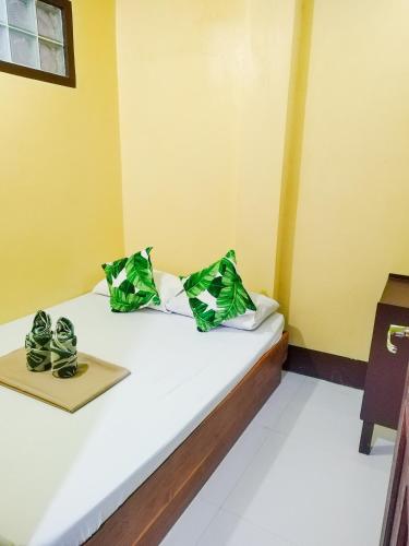 a room with a bed with green bags on it at Joyful Guest House in El Nido