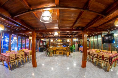 um restaurante com mesas e cadeiras num quarto em Xoè Homestay Trạm Tấu em Cham Ta Lao