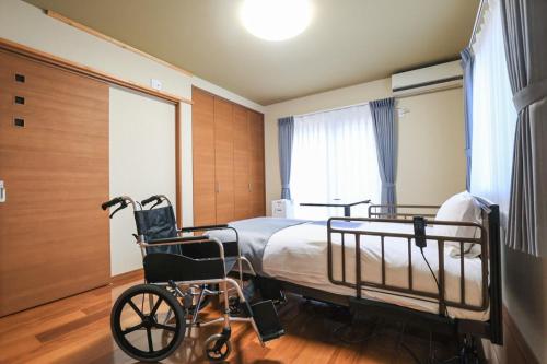 a hospital room with a bed and a wheelchair at 24 ORIYA Mt Fuji -鳴沢 NARUSAWA- in Narusawa