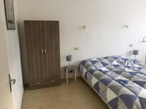 sypialnia z łóżkiem i drewnianą szafką w obiekcie Appartement F2 avec Terrasse et Parking, Proche Cures et Centre-ville - Amélie-les-Bains - FR-1-703-142 w mieście Amélie-les-Bains-Palalda