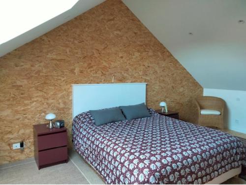 une chambre avec un lit et un mur en bois dans l'établissement Maison rénovée avec goût, proche plage et marché, 6 couchages, terrasse, Wi-Fi, non fumeur - FR-1-331-220, à Les Sables-dʼOlonne