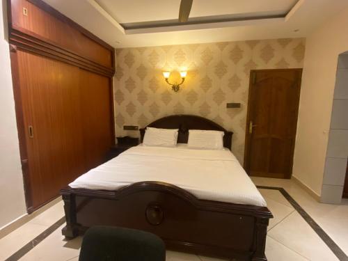 a bedroom with a bed with a wooden headboard at Queen's in Trivandrum