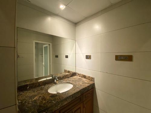 uma casa de banho com um lavatório e um espelho em Queen's em Trivandrum