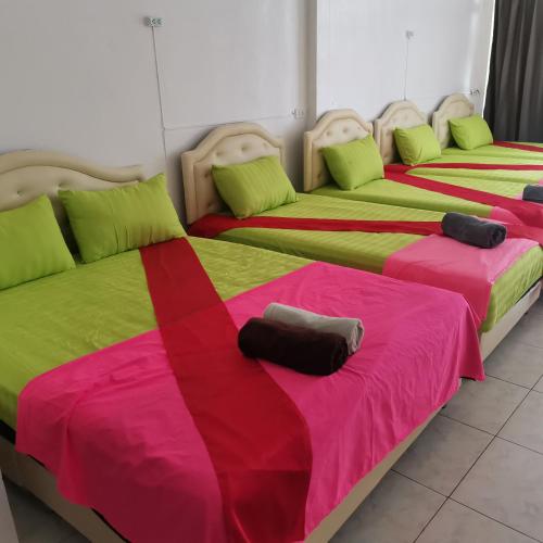 two beds with colorful blankets and pillows in a room at Haadrin village Fullmoon in Haad Rin