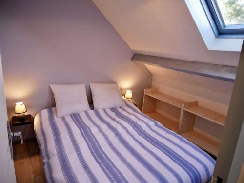 een slaapkamer met een bed met 2 kussens en een raam bij Maison Erdeven, 3 pièces, 4 personnes - FR-1-479-108 in Erdeven