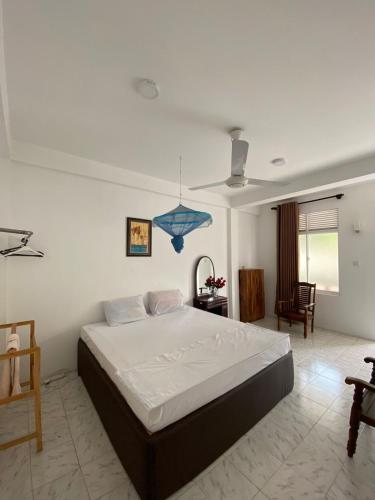a bedroom with a large bed and a blue light at senarathna guest house in Weligama