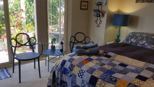 1 dormitorio con cama, sillas y ventana en Blue Wren Retreat, en Orange