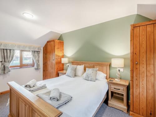 a bedroom with a large white bed and a window at Barn House in Friskney