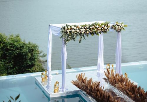 a wedding arch with a flower arrangement on the edge of a pool at The Serenity Resort in Tariyod