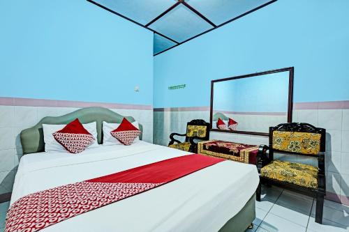 1 dormitorio con 1 cama grande y 2 sillas en OYO 92282 Hotel Muria, en Yogyakarta