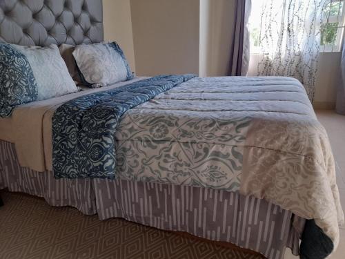 a bedroom with a bed with a blue and white comforter at Ultimate Chill Montego Bay in Montego Bay